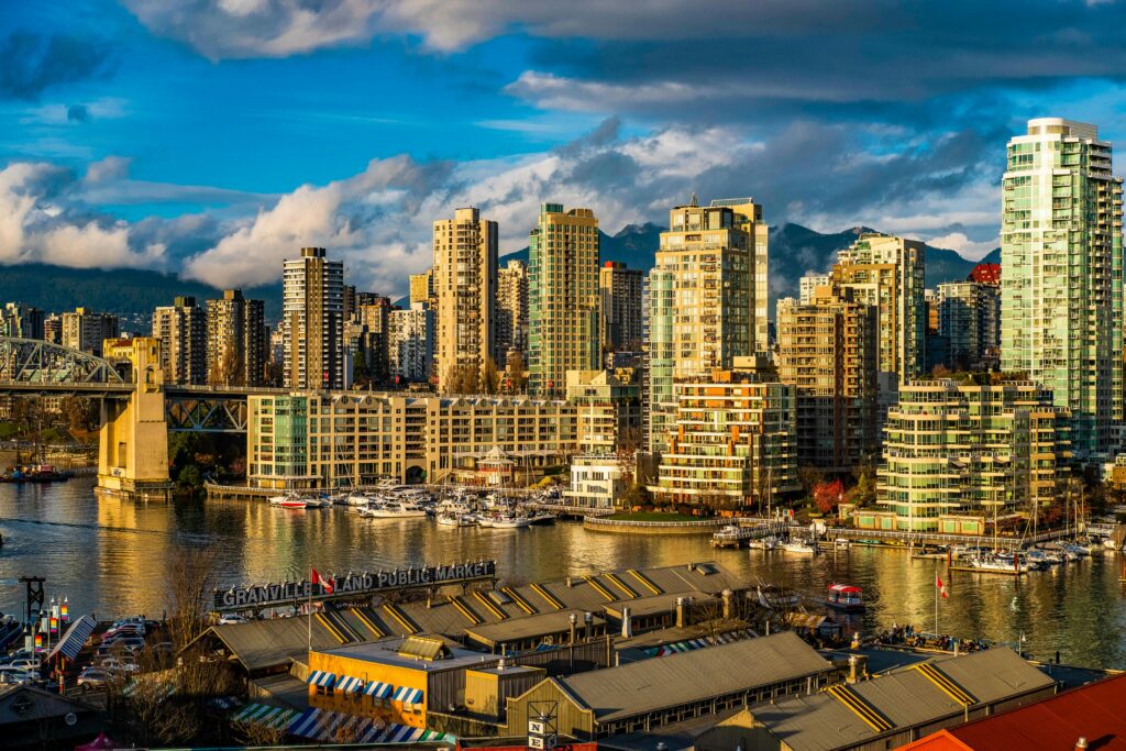 Beautiful view of Vancouver's modern skyline and Granville Island public market at sunset.